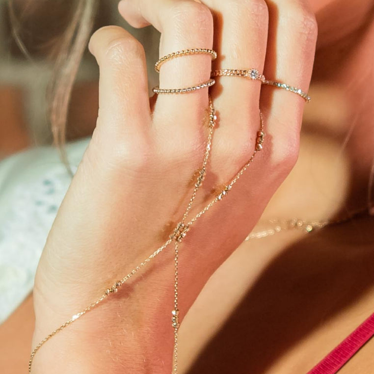 Woman wearing wanderlust hand chain and rings